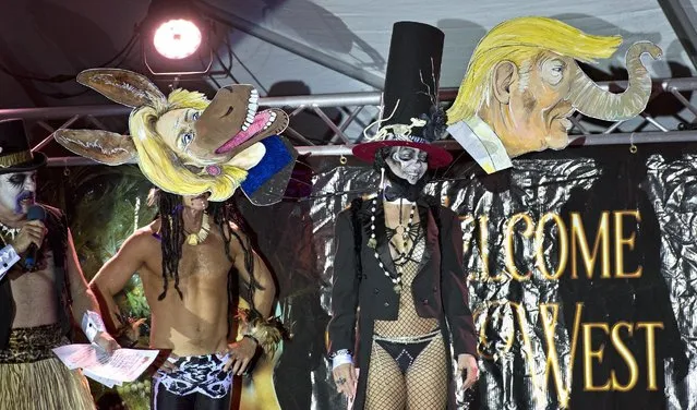 In this Thursday, October 27, 2016, photo provided by the Florida Keys News Bureau, Janet Lee, right, displays her presidential election-themed headdress at the Fantasy Fest Headdress Ball in Key West, Fla. Organized by the Key West Business Guild, the event was one of more than 40 that are being staged during the island city's 10-day Fantasy Fest costuming and masking festival that ends Sunday, Oct. 30. (Photo by Rob O'Neal/Florida Keys News Bureau via AP Photo)