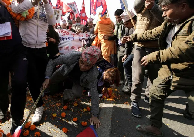 A supporter of monarchy, celebrating the birth anniversary of the late king Prithvi Narayan Shah who formed present Nepal centuries ago, falls as the demonstrators try to break the police line during clashes amid a row over their route for the rally in Kathmandu, Nepal on January 11, 2021. (Photo by Navesh Chitrakar/Reuters)