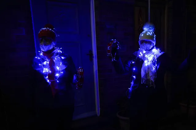 Two residents from the same household wear fairly lights as they take part in the Clap for Heroes event on January 14, 2021 in Saltburn-by-the-Sea, England. During the first Coronavirus pandemic lockdown, beginning in March 2020, people took to their doorsteps, windows and balconies on each Thursday for ten weeks to celebrate NHS staff and key workers with a round of applause. Founder of Clap for Carers, Annemarie Plas, said “We are bringing back the 8pm applause, in our 3rd lockdown”. This time it is renamed Clap for Heroes. (Photo by Ian Forsyth/Getty Images)