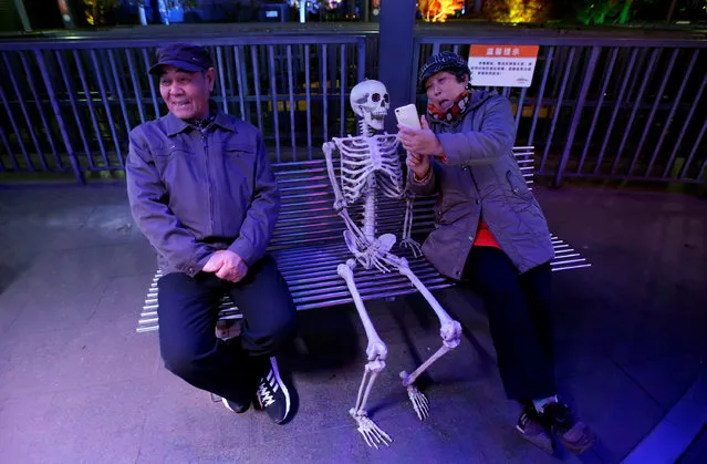 A woman takes a selfie with a fake skeleton next to her husband ahead of a Halloween parade at Happy Valley park in Beijing, China October 31, 2016. (Photo by Jason Lee/Reuters)