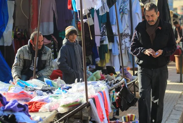 Men display clothes for sale in Idlib, Syria December 6, 2015. (Photo by Ammar Abdullah/Reuters)