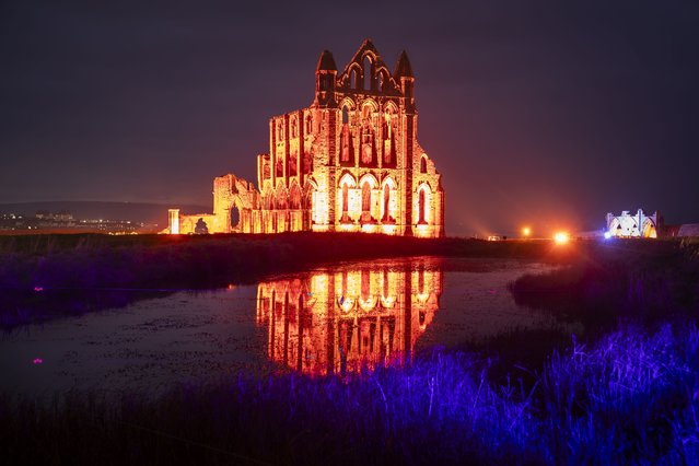 Lights illuminate the ruins of Whitby Abbey in North Yorkshire to mark Halloween on Wednesday, October 30, 2024. Visitors to the nightly display at the English Heritage property, which was the inspiration for Bram Stoker's Dracula, can also experience the world of Victorian gothic with a production of “If these Stones could Talk” from the Time Will Tell theatre group. (Photo by Danny Lawson/PA Images via Getty Images)