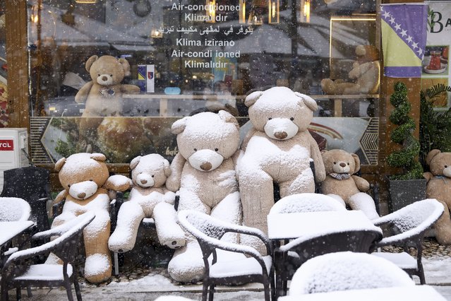 Teddy bears are seen covered with snow outside a cafe in downtown Sarajevo, Bosnia, Monday, December 23, 2024. (Photo by Armin Durgut/AP Photo)