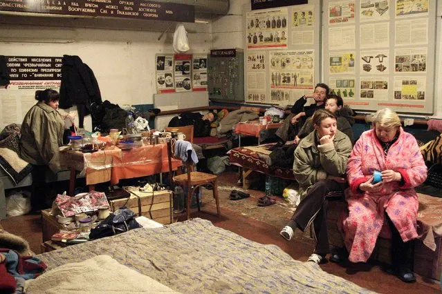 Local residents sit inside a bomb shelter on the outskirts of Donetsk, January 28, 2015. (Photo by Alexander Ermochenko/Reuters)