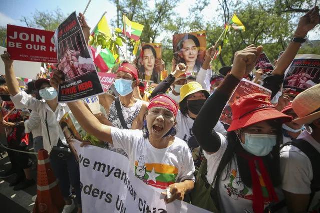 Myanmar nationals living in Thailand hold pictures of deposed Myanmar leader Aung San Suu Kyi as they protest against the military coup in front of the United Nations building i in Bangkok, Thailand, Sunday, March 7, 2021. (Photo by Nava Sangthong/AP Photo)
