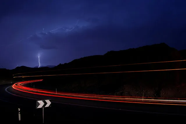 Cars drive as lightning strikes near the site where a group of Israeli youths was swept away by a flash flood, near the Zafit river bed, south to the Dead Sea, Israel, April 26, 2018. (Photo by Amir Cohen/Reuters)