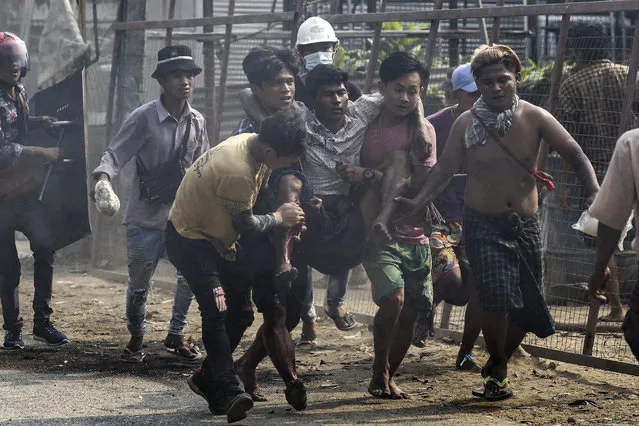 Protesters carry an injured demonstrator during a protest against the military coup in Hlaingthaya (Hlaing Tharyar) Township, outskirts of Yangon, Myanmar, 14 March 2021. Anti-coup protests continued despite the intensifying violent crackdowns on demonstrators by security forces. (Photo by EPA/EFE/Stringer)