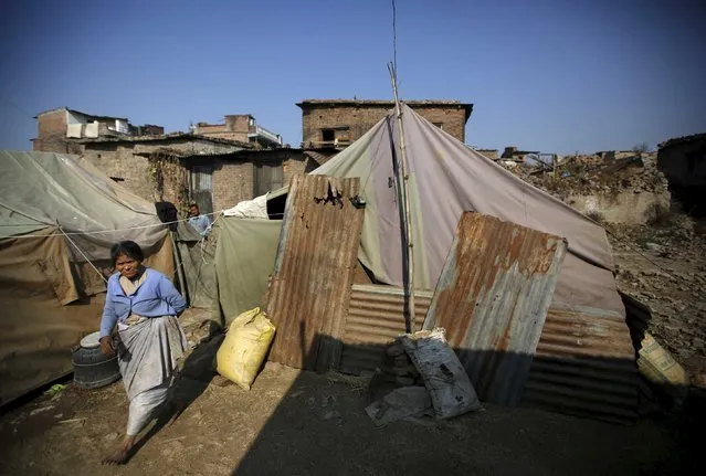 A woman walks along the temporary shelter built near the houses damaged during an earthquake earlier this year, in Bhaktapur, Nepal December 28, 2015. (Photo by Navesh Chitrakar/Reuters)