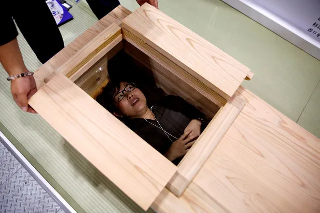 A visitor lies in a coffin to try it out at the ENDEX JAPAN 2018 funeral and cemetery show in Tokyo, Japan on August 22, 2018. (Photo by Toru Hanai/Reuters)