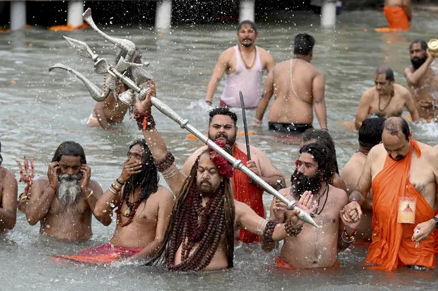 Sadhus (Hindu holy men) take a holy dip in the waters of the Ganges River on the day of Shahi Snan (royal bath) during the ongoing religious Kumbh Mela festival, in Haridwar on April 12, 2021. (Photo by Money Sharma/AFP Photo)