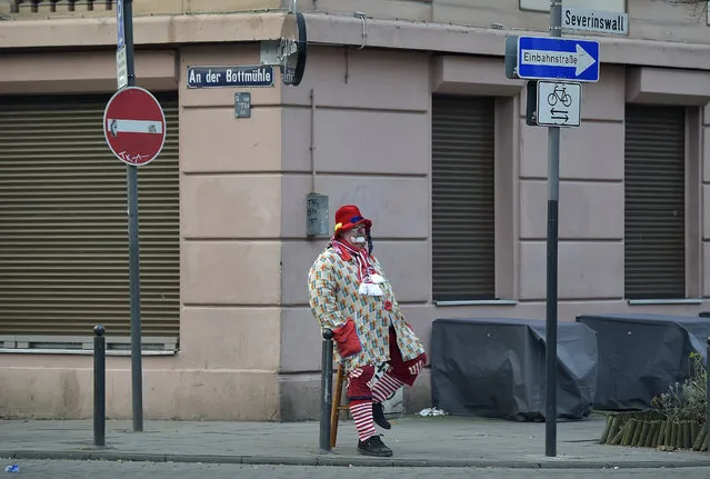 A lonely clown waits alone early morning for the carnival parade in Cologne, western Germany, Monday, February 16, 2015. (Photo by Martin Meissner/AP Photo)