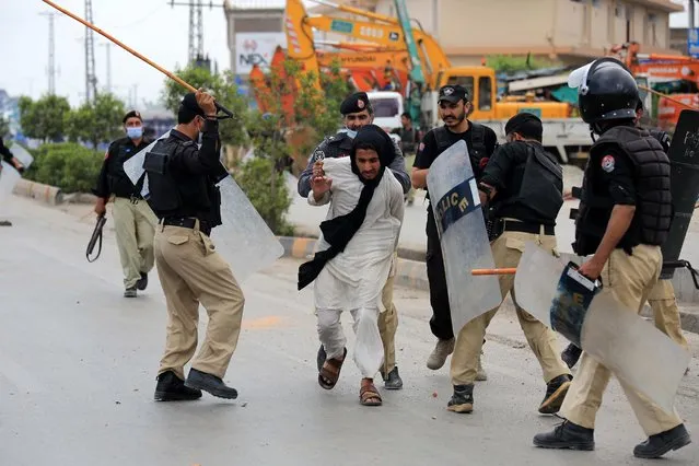 Police clash with supporters of Islamic political party Tehreek-e-Labbaik Pakistan (TLP), after they blocked a road to demand the release of their leader Saad Hussain Rizvi, in Peshawar, Pakistan, 13 April 2021. On 12 April, Pakistani authorities arrested Rizvi who has demanded that the French ambassador be expelled by 20 April, as supposedly agreed with the government earlier, resulting in protests and a blockade of roads by his supporters. The radical group Tehreek-e-Labbaik Pakistan (TLP), led by the detained Islamist Saad Hussain Rizvi, led a blockade of the Pakistani capital by multiple hardline groups in November to protest against the caricatures of Prophet Mohammad and French President Emmanuel Macron's comments on Islam, considered blasphemous by Muslims. (Photo by Bilawal Arbab/EPA/EFE)