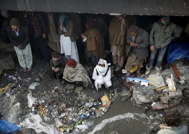 People shelter under the Pul-e Sokhta bridge in western Kabul, during a police round up of suspected drug addicts December 27, 2015. (Photo by Ahmad Masood/Reuters)