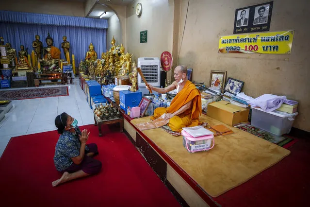 A devotee receives a blessing from a Buddhist monk after taking part in a “live funeral” ritual at Bangna Nai temple in Bangkok, Thailand, 13 February 2021. (Photo by Diego Azubel/EPA/EFE)