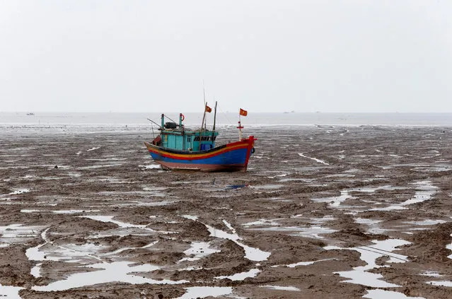 A fishing boat is seen during the low tide at the beach in Thanh Hoa province, Vietnam June 4, 2018. (Photo by Reuters/Kham)