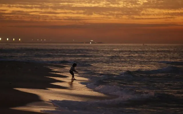 A Palestinian girl plays on the beach of Gaza City after sunset, February 6, 2015. (Photo by Mohammed Salem/Reuters)