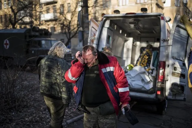 A member of Ukrainian military medical unit cries for his four comrades killed near Debaltseve during a ceremony in Artemivsk, eastern Ukraine, Monday, Feb. 23, 2015. Ukraine delayed a promised pullback of heavy weapons from the front line Monday in eastern Ukraine, blaming continuing attacks from separatist rebels. (AP Photo/Evgeniy Maloletka)