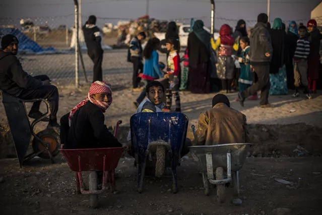 Iraqi youth sit in a wheelbarrow in Khazer camp for the displaced, Iraqi Kurdistan, Iraq, Monday, December 12, 2016. A new report criticizes the U.S.-led coalition against IS for their lack of transparency when assessing civilian casualties. (Photo by Manu Brabo/AP Photo)