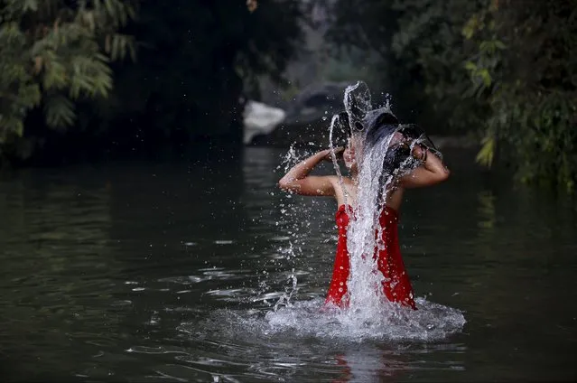 A devotee takes a holy bath in River Saali in Sankhu during the Swasthani Brata Katha festival in Kathmandu, Nepal, January 24, 2016. (Photo by Navesh Chitrakar/Reuters)