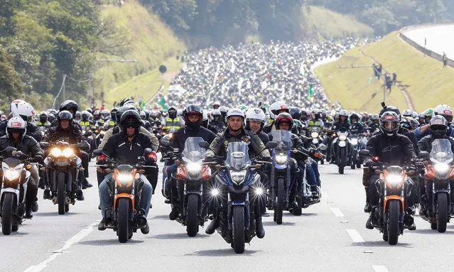 A handout photo made available by the Presidency of Brazil that shows the Brazilian President, Jair Bolsonaro (C), during a motorcycle tour with his followers, in Sao Paulo, Brazil, 12 June 2021. Bolsonaro, one of the world leaders most skeptical of the severity of the coronavirus, once again defied the pandemic and, ignoring local agglomeration bans, led a massive motorcyclist caravan in Sao Paulo. Bolsonaro participated in the caravan called by his supporters, and without wearing a mask he led the gigantic parade of thousands of motorcyclists that gathered outside the Anhembi sambadrome. (Photo by Alan Santos/Presidency of Brazil/EPA/EFE)