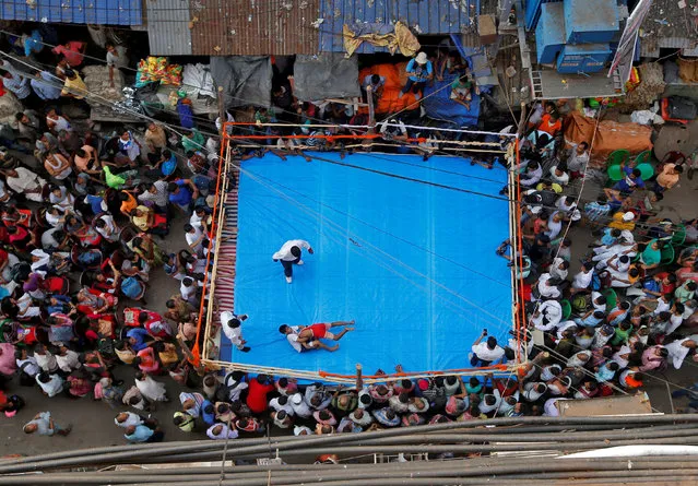 Wrestlers fight during an amateur wrestling match inside a makeshift ring installed on a road organised by local residents as part of Diwali, the festival of lights, celebrations in Kolkata, India, November 5, 2018. (Photo by Rupak De Chowdhuri/Reuters)