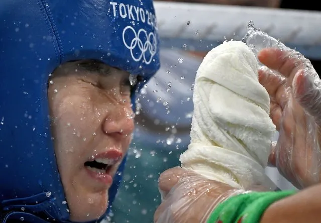 Tursunoy Rakhimova of Uzbekistan reacts as trainers use water in her corner during a Women's fly weight 48-51 kg boxing match against Buse Naz Cakiroglu of Turkey at the 2020 Summer Olympics, Thursday, July 29, 2021, in Tokyo, Japan. (Photo by Luis Robayo/Pool Photo via AP Photo)