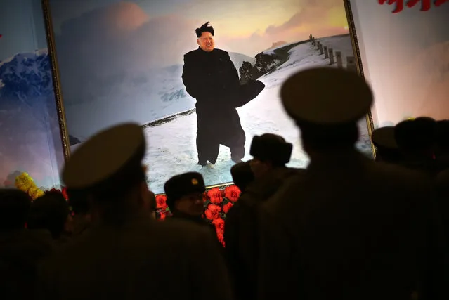 Military soldiers are silhouetted against a portrait of North Korean leader Kim Jong Un at a flower festival as part of celebrations a day before the birthday anniversary, also known as the “Day of the Shining Star”, of late North Korean leader Kim Jong Il on Monday, February 15, 2016, in Pyongyang, North Korea. On Tuesday, Feb. 16, North Korea marks the late leader Kim Jong Il's 74th birthday anniversary. (Photo by Wong Maye-E/AP Photo)