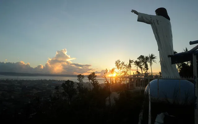 A general shot shows a religious statue (R) overlooking a view of downtown Tacloban, Leyte province on December 9, 2013. Philippine President Benigno Aquino is to seek more aid when he meets with Japanese Prime Minister Shinzo Abe this week, more than a month after a monster typhoon killed thousands and left millions homeless. (Photo by Noel Celis/AFP Photo)