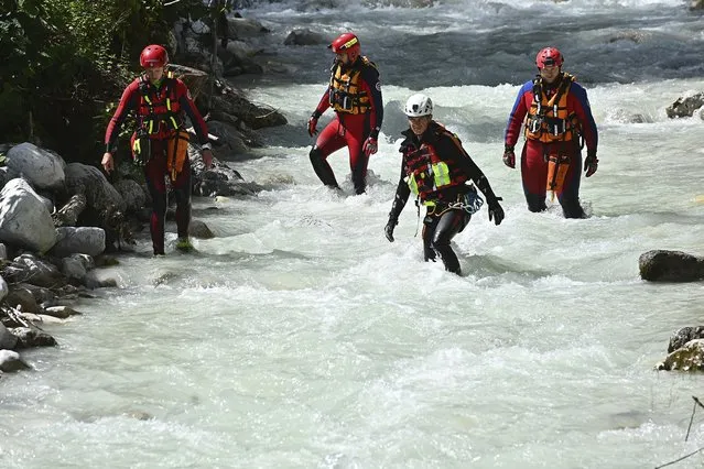 Emergency teams of the water rescue service search the Hammersbach and the shore area near the Hoellentalklamm gorge in Grainau, Germany, Tuesday, August 17, 2021. After the flood wave in the gorge at the Zugspitze region, the search for missing persons continues. After heavy rainfall on Monday, Aug. 16, 2021, a flood wave rushed through the gorge near Grainau in the district of Garmisch-Partenkirchen, which is popular with hikers and tourists. (Photo by Lennart Preiss/dpa via AP Photo)