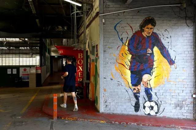 A man walks past a mural of Lionel Messi in Glasgow, Scotland on September 11, 2023, before an international friendly football match between Scotland and England. (Photo by Carl Recine/Reuters)