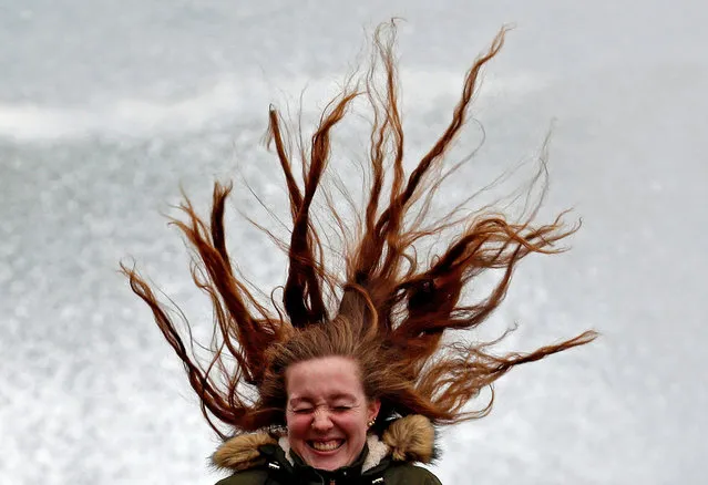 A woman reacts as her hair blows in the air on windy day in San Sebastian, in the Basque Country, northern Spain, 31 January 2019. The Basque Department of Security has issued an orange-level alert due to bad sea with waves reaching up to 6 meters high. (Photo by Juan Herrero/EPA/EFE)