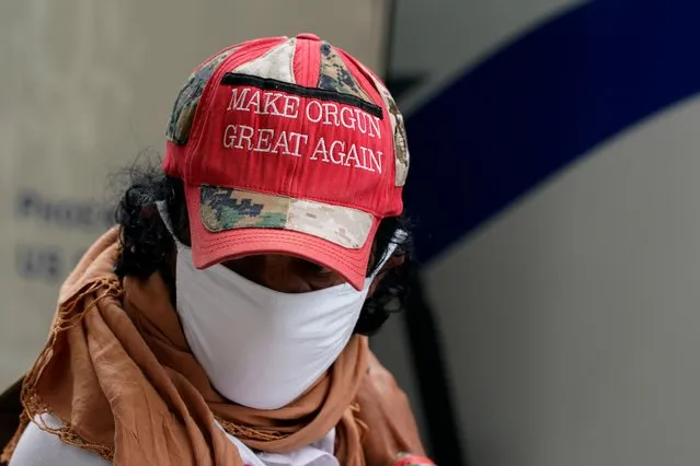 A man wearing a hat that reads “Make Orgun Great Again” boards a bus taking him and other Afghan refugees to a processing center upon arrival at Dulles International Airport in Dulles, Virginia, U.S., August 29, 2021. (Photo by Elizabeth Frantz/Reuters)