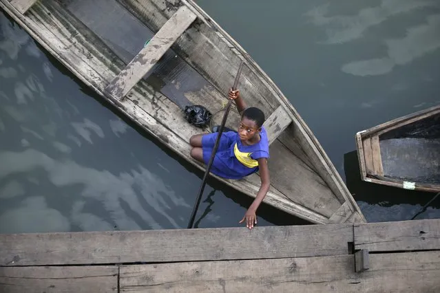 A student arrives at a floating school on a canoe in the Makoko fishing community on the Lagos  Lagoon, Nigeria February 29, 2016. (Photo by Akintunde Akinleye/Reuters)