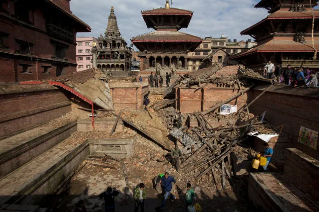 People remove carvings from the rubble in Patan Durbar Square, Nepal, on April 27, 2015. (Photo by Brian Dawson/The Washington Post)