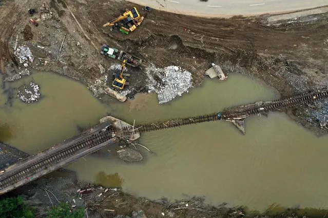 An aerial view shows railroad tracks destroyed by the flood in the wine village Rech near Dernau, Rhineland-Palatinate, western Germany, on August 19, 2021, weeks after heavy rain and floods caused major damage in the Ahr region. (Photo by Ina Fassbender/AFP Photo)