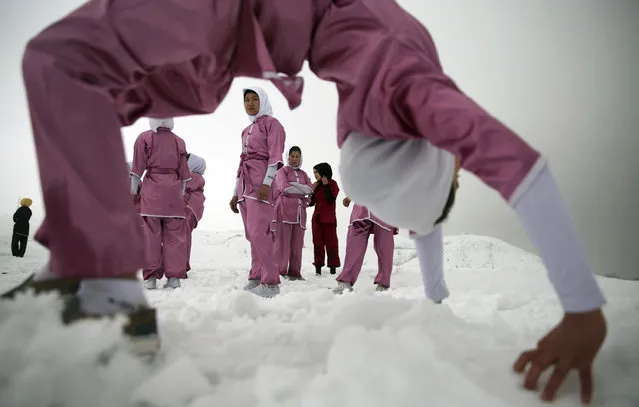 Shaolin martial arts students practice on a hilltop in the snow, in Kabul, Afghanistan, Tuesday, January 25, 2017. The ten ethnic Hazara women are preparing for the day that Afghanistan can send its women’s team to the Shaolin world championship in China. (Photo by Massoud Hossaini/AP Photos)