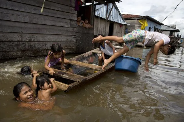 Children play on a boat in the water outside their homes in the Belen neighborhood of Iquitos, Peru on April 19, 2015. This impoverished Peruvian Amazon community, nicknamed “Venice of the Jungle”, lives half the year on the water, with canoes replacing motorcycle taxis as the most popular form of transport. (Photo by Rodrigo Abd/AP Photo)