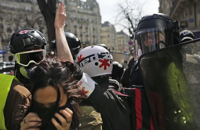 Protesters scuffle with police during a rally in Paris, France, Saturday, April 6, 2019. Protesters from the yellow vest movement are taking to the streets of France for a 21st straight weekend, with hundreds gathered for a march across Paris, one of numerous protests around the country. (Photo by Rafael Yaghobzadeh/AP Photo)