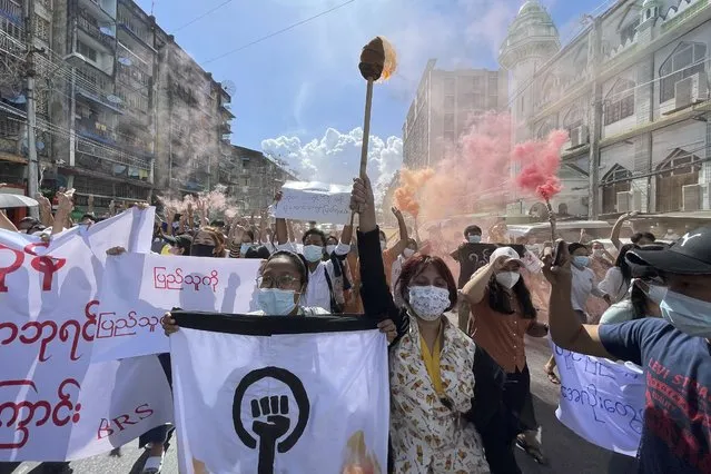 Protesters march holding slogans during a protest at Pazundaung township in Yangon, Myanmar, Wednesday July 14, 2021. (Photo by AP Photo/Stringer)