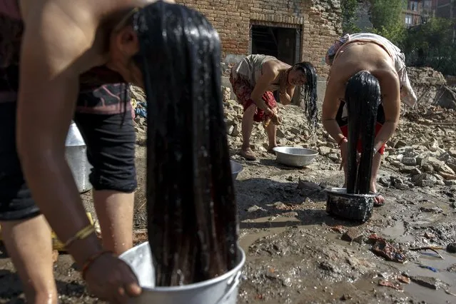 Local residents clean their bodies next to their homes which were destroyed after last week's earthquake in Bhaktapur, Nepal, May 4, 2015. (Photo by Athit Perawongmetha/Reuters)