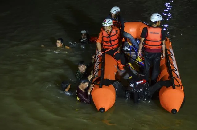 Rescuers search for victims of drowning in a river in Ciamis, West Java, Indonesia, Friday, October 15, 2021. A number of students drowned during a school outing for a river cleanup on Friday evening in Indonesia's West Java Province. (Photo by Yopi Andrias/AP Photo)