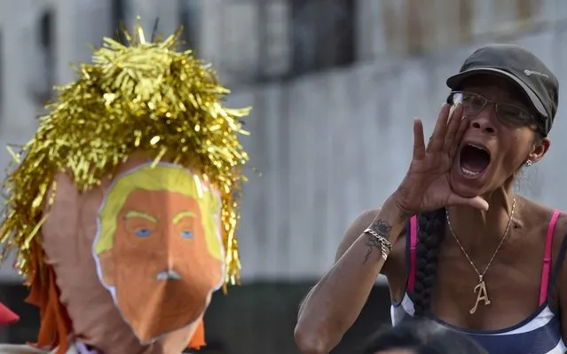 A supporter of Venezuelan President Nicolas Maduro shouts slogans as a dummy depicting US President Donald Trump is prepared to be burnt, during the traditional "burning of Judas" on Easter Day at Venezuela square, in Caracas, on April 21, 2019. (Photo by Yuri Cortez/AFP Photo)