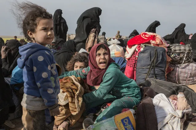 Civilians fleeing from Islamic State’s last remaining territory in Syria after two days of heavy fighting wait to be taken to an internment camp on 5 March 2019. (Photo by Sam Tarling/Daily Telegraph)