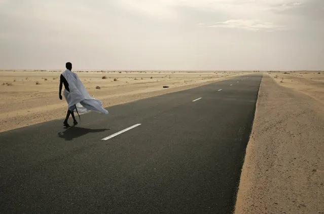 A man walks on the road between Nouahibou and Nouakchott, where three Spanish aid workers were abducted in Mauritania, December 3, 2009. (Photo by Rafael Marchante/Reuters)