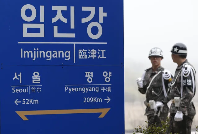 South Korean soldiers walk by a signboard showing the distance to the North Korea's capital Pyongyang and to South Korea's capital Seoul from Imjingang Station near the border village of the Panmunjom in Paju, South Korea, April 9, 2016. North Korea said Saturday it has successfully tested a new intercontinental ballistic rocket engine that will give it the ability to stage nuclear strikes on the United States. (Photo by Lee Jin-man/AP Photo)