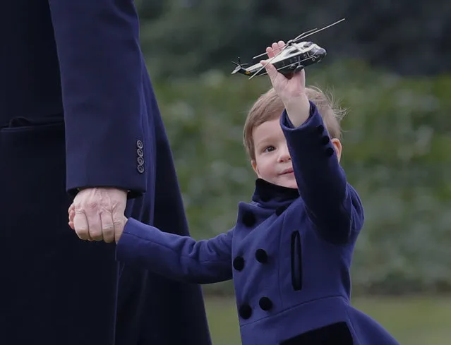 President Donald Trump's grandson Joseph Kushner holds a model of Marine One, as they walk across the South Lawn of the White House in Washington, Friday, March 3, 2017, before boarding Marine One for the short flight to nearby Andrews Air Force Base, Friday, March 3, 2017. (Photo by Pablo Martinez Monsivais/AP Photo)