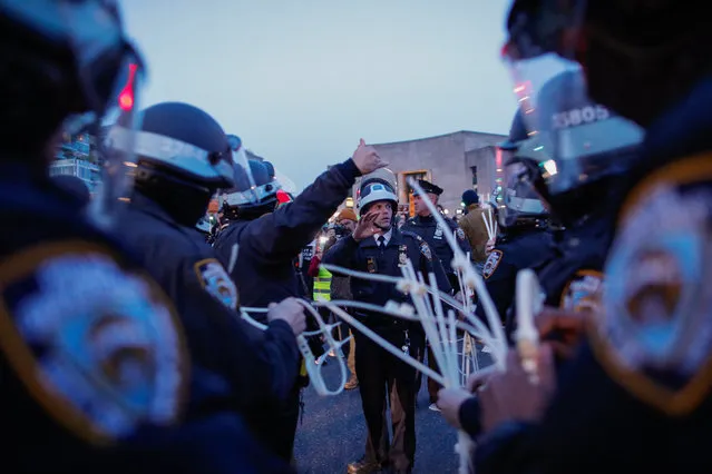 Police officers hold plastic handuffs as they prepare to detain protesters blocking a street near the home of US Senate Majority Leader Chuck Schumer in the Brooklyn borough of New York during a demonstration by pro-Palestinian Jewish groups on the second night of Passover calling on Schumer to stop arming Israel amid its retaliatory assault on the Gaza Strip on April 23, 2024. (Photo by Kena Betancur/AFP Photo)