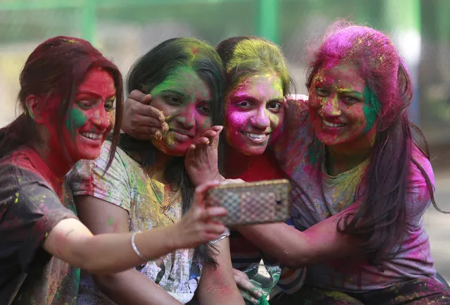 Indian girls take selfie as they celebrate Holi, the Hindu festival of colors, in Mumbai, India, Monday, March 13, 2017. (Photo by Rafiq Maqbool/AP Photo)