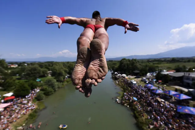 A man jumps from the 22 meters high bridge “Ura e Shenjte” during the annual traditional High Diving competition near the town of Gjakova on July 22, 2019. (Photo by Armend Nimani/AFP Photo)