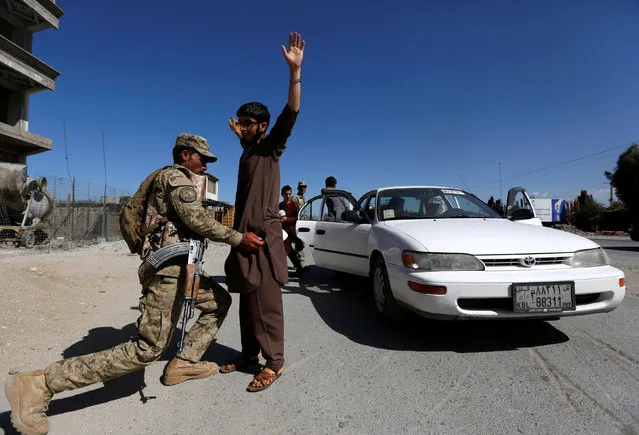 An Afghan policeman inspects passengers at a checkpoint on the outskirts of Jalalabad province, Afghanistan, April 29, 2016. (Photo by Reuters/Parwiz)